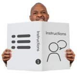 A man holding up a book with instructions written on.
