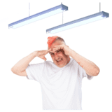 A man covering his eyes from strip lights above him.
