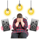 A person with speakers and lights next to them with their head in their hands.